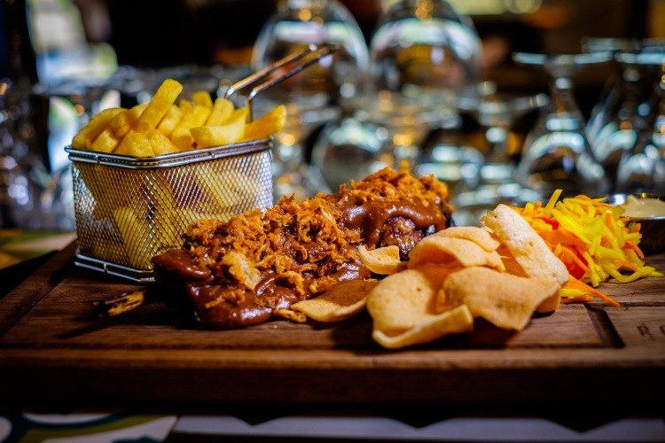 Frietjes in een presenteermandje: het simpele plezier van comfortfood, geserveerd met een vleugje charme.